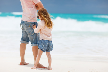 Father and his adorable little daughter at tropical beachの写真素材