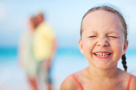 Adorable little girl and her family on a beach vacationの写真素材