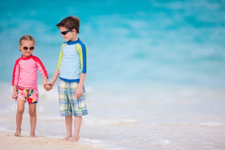 Brother and sister enjoying time at tropical beachの写真素材