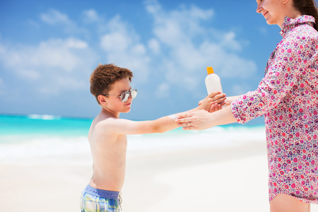 Close up of a mother applying sunblock cream on her sonの写真素材