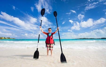 Little boy holding kayak paddles at beachの写真素材