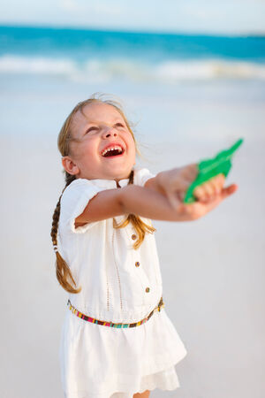 Close up of little girl flying a kite at beachの写真素材