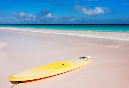 Yellow surfboard at tropical beach on Bahamas