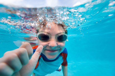Portrait of a cute little boy swimming underwaterの写真素材