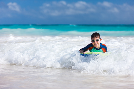 Little boy on vacation having fun swimming on boogie boardの写真素材