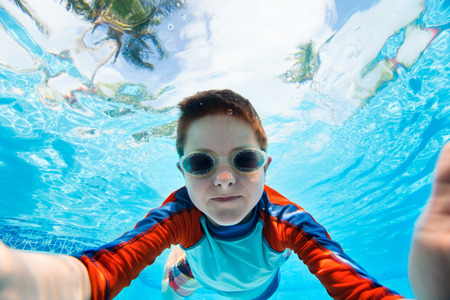 Cute little boy underwater in swimming poolの写真素材