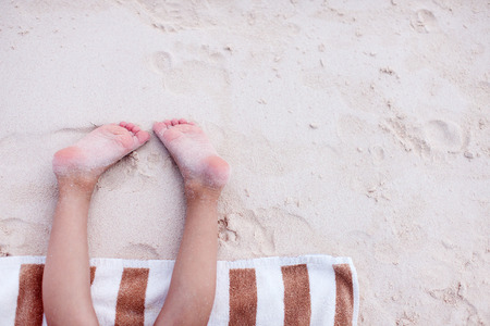 Close up of a little girl resting on a beach towelの写真素材
