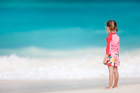 Back view of cute little girl at tropical beachの写真素材