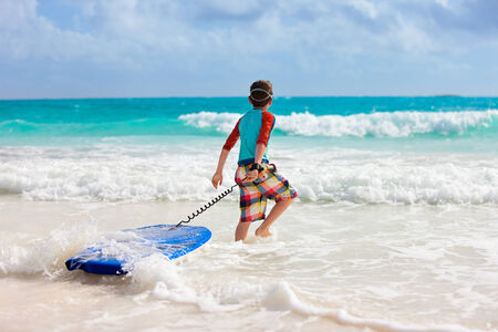 Little boy on vacation having fun surfing on boogie board