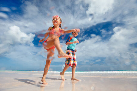 Happy kids running and jumping at beachの写真素材