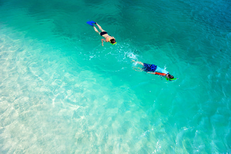 Above view of  mother and son snorkeling in a clear tropical waterの写真素材