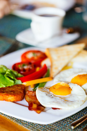 Delicious breakfast with fried eggs, vegetables and toastの写真素材