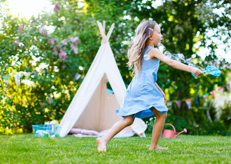 Adorable little girl having fun playing outdoors on summer dayの写真素材