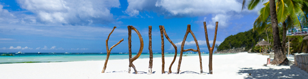 Panorama of postcard perfect exotic beach with white sand and turquoise clear water on tropical island with wooden letters making Friday wordの写真素材