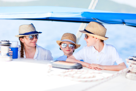 Mother and her kids having great time sailing at luxury yacht or catamaran boatの写真素材