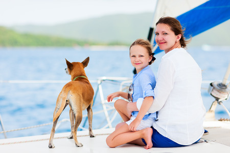Mother, daughter and their pet dog sailing on a luxury yacht or catamaran boatの写真素材