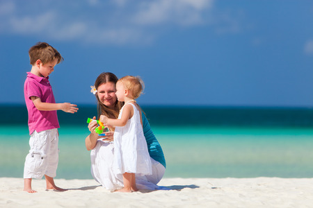 Young mother with her two kids on tropical beach vacationの写真素材