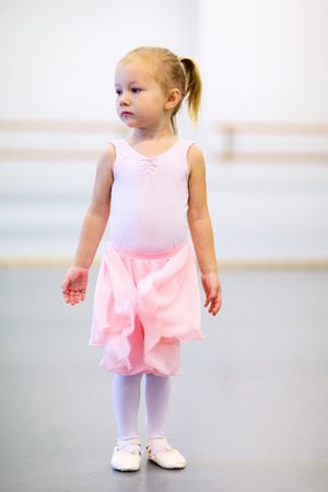 Adorable little ballerina wearing pink leotard in a dancing schoolの写真素材