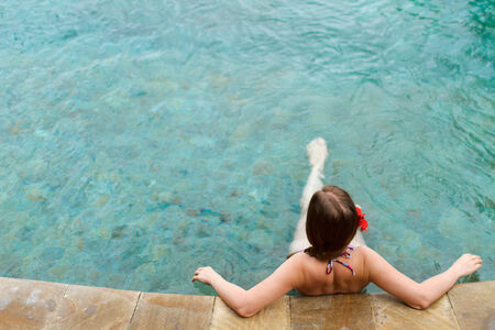 Above view of beautiful woman relaxing in swimming poolの写真素材