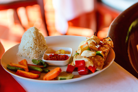Fish skewers, rice and fresh vegetables served for lunchの写真素材