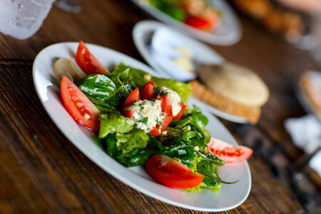 Fresh organic salad made of green lettuce, tomatoes and sproutsの写真素材