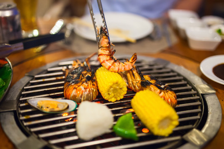 Close up of fresh seafood and vegetable preparing on grillの写真素材