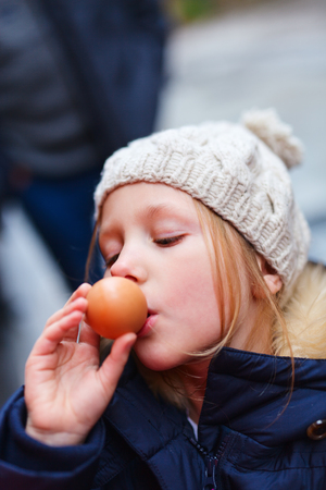 Little girl trying egg soft boiled in Japanese hot springsの写真素材