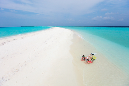 Above view of mother and kids enjoying tropical beach vacationの写真素材