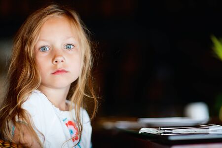 Portrait of adorable little girl with blonde curly hair and green eyesの写真素材