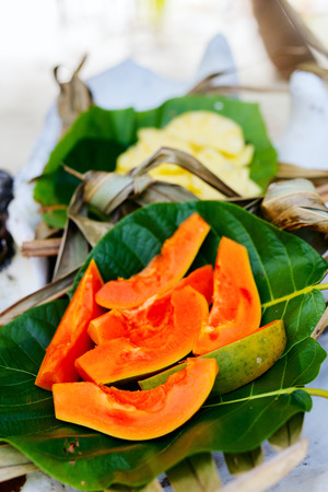 Close up of slices of sweet papaya served on weaved platterの写真素材
