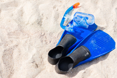 Snorkeling equipment mask, snorkel and fins on sand at beachの写真素材