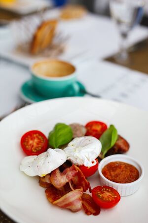 Poached eggs served for breakfast with vegetables and coffeeの写真素材