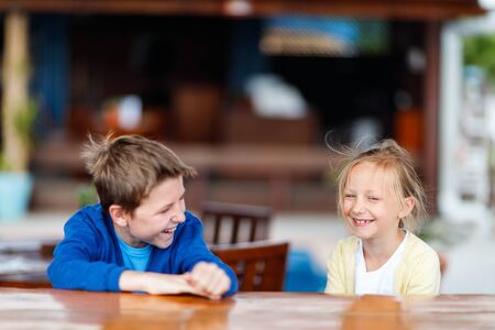 Brother and sister wearing sweaters outdoors on summer, spring or autumn dayの写真素材