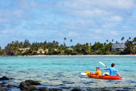 Father and son kayaking at tropical oceanの写真素材