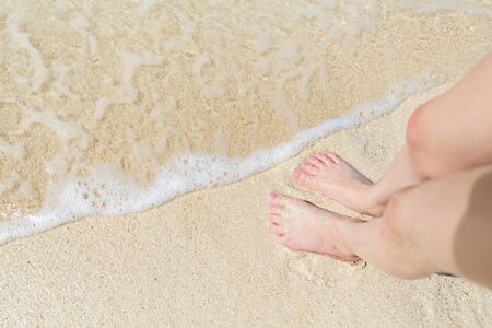 Close up of a little girl feet on tropical sandy beachの写真素材