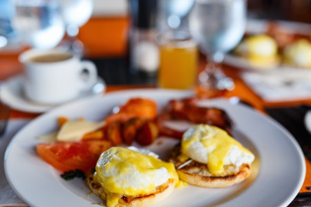 Delicious breakfast with eggs Benedict, bacon, orange juice and coffeeの写真素材