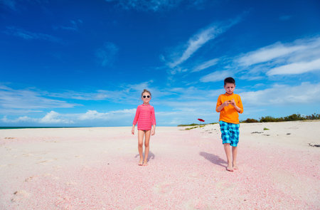 Kids brother and sister at unique pink sand beach on Barbuda tropical island in Caribbeanの写真素材