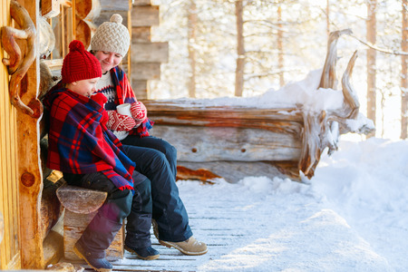 Beautiful family of mother and her little daughter enjoying snowy winter day outdoorsの写真素材