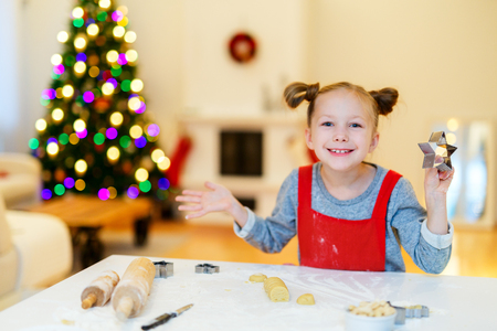 Little girl baking Christmas cookies at homeの写真素材