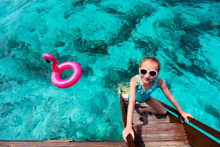 Top view of adorable little girl swimming in tropical ocean in Maldivesの写真素材
