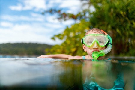 Adorable little girl at swimming pool having fun during summer vacationの写真素材