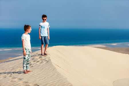 Kids having fun playing together at sand dunes in Qatar desertの写真素材