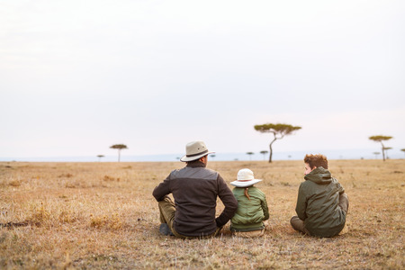 Family of father and kids on African safari vacation enjoying views over Masai Mara in Kenyaの写真素材