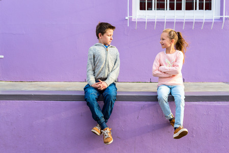 Two kids boy and girl outdoors against colorful house in Bo Kaap Quarter in Cape Townの写真素材