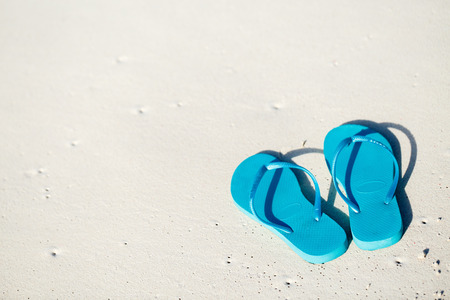 Turquoise flip flops on a tropical beachの写真素材