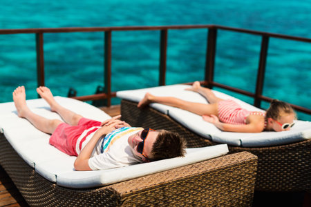 Kids enjoying tropical summer vacation relaxing at overwater villa in luxury resportの写真素材