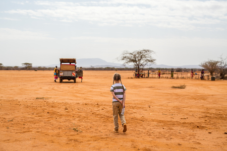 Adorable little girl in Kenya safari walking towards open vehicleの写真素材