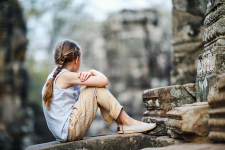 Little girl at ancient Preah Khan temple in Angkor Archaeological area in Cambodiaの写真素材