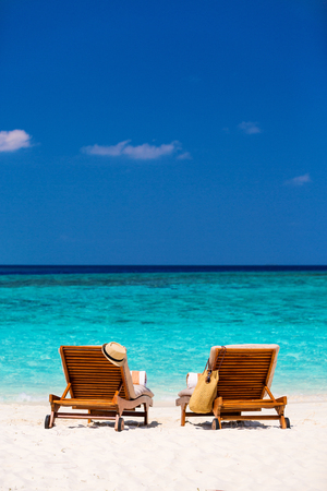 Wooden lounge chairs on a beautiful tropical beach at Maldivesの写真素材