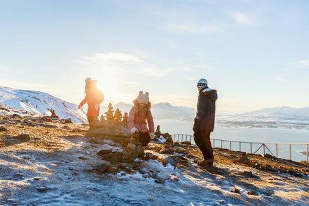 Beautiful family of mother and kids have a pleasant time on snowy winter day outdoors enjoying views...